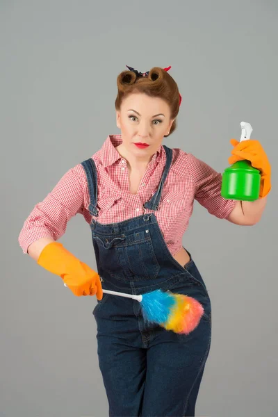 家の掃除と水噴霧器とカラフルなほこりブラシを保持しながら深刻な探している自信の主婦 — ストック写真