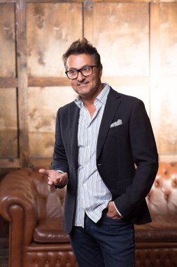 Şık takım elbise ve süre söz ve hareketleri kullanarak gülümseyen neşeli rahat iş adamı