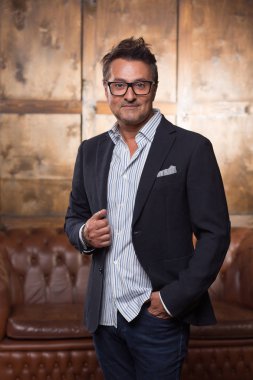 Şık şık kıyafetlerle ve ceketini dokunmaktan ve sana bakmak süre gülümseyerek emin duygusal orta yaşlı adam