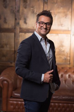 Zarif elbise giyiyor ve mutlu bir şekilde ceketinin bir parçası dokunmadan süre gülümseyen pozitif yakışıklı işadamı