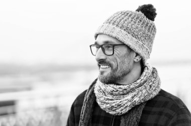 Gözlük ve flanel ceket genç gülümseyen adam profil portresi. Kış için kentsel erkek giyim örme. Profil gözlük ve örme eşarp mutlu sakallı adam. Topu ile şapkalı adam inek. Kentsel geek portre