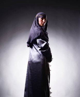 Seyir sırt uzun lüks kostüm ve zengin takı ile baş kapak giyerken ciddi prensesi arkadan görünüş