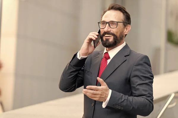 Um bom negócio! Homem de negócios barbudo fala por smartphone. Sorrindo formal vestido empresário falando no telefone celular com os clientes — Fotografia de Stock