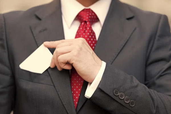 Vértes üzletember kezében egy névjegykártyát felső ruha zsebbel. Zár-megjelöl-ból ember kéz-kártyával — Stock Fotó