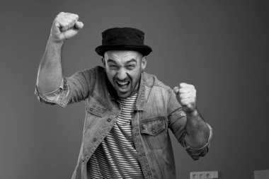 Neşeli ifade adam yumruklarını yukarı kaldırarak sesinin üstüne bağırarak