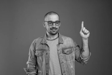 Sakin çekici adam işaret parmağını yukarı tutarken bakışLarını ön