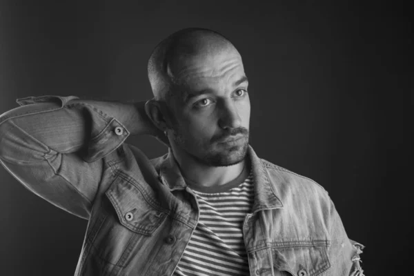 Kafasının arkasında kolunu tutan düşünceli kel adamın portresi
