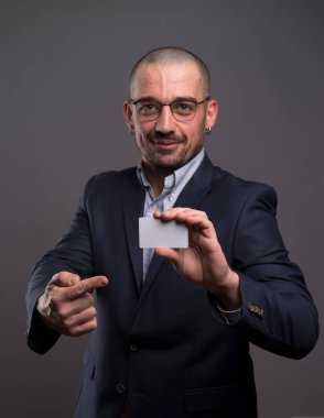 Pozitif giyinmiş bir adam kredi kartı sunuyor.