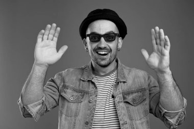 Kot ceketli, heyecanlı karizmatik adam ellerini havada tutuyor.