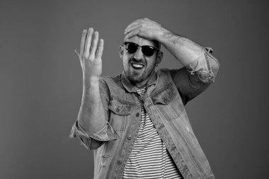 Kafasına dokunurken pişmanlık duyan hayal kırıklığına uğramış genç bir adam.