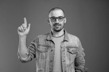 Pozitif karizmatik bir adam işaret parmağını yukarı kaldırıyor.