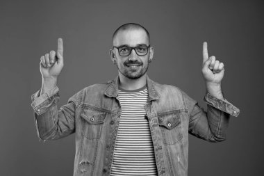 Her iki işaret parmağıyla yukarıya bakan karizmatik, zeki bir adam.