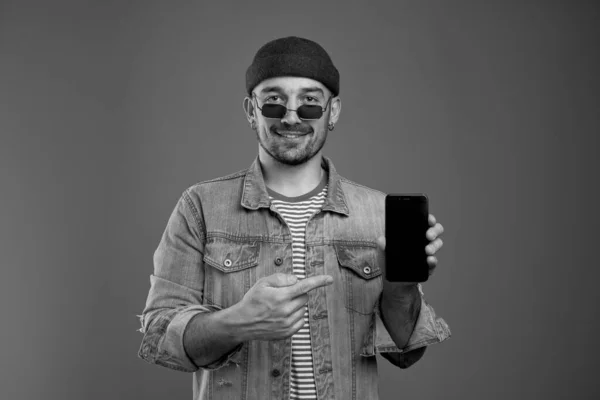 Portrait of stylish handsome man pointing at new smartphone mode