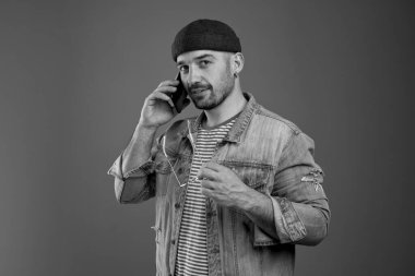 Sakin, modaya uygun bir adam cep telefonuyla konuşuyor.