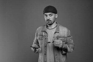 Gözlüklü ve akıllı telefonlu düşünceli bir adamın portresi.