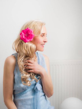 Şık bir evde sofistike sarışın bir kadının dikey portresi.