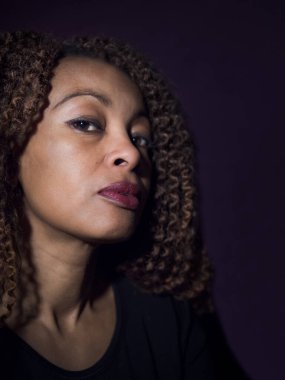 Gururlu ve kızgın görünen Afro-Amerikan bir kadının dikey portresi