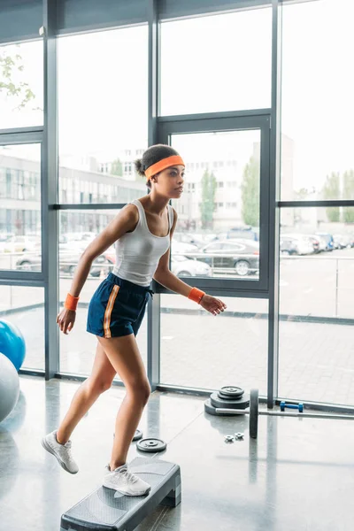 Afroamerikanska Idrottskvinna Pannband Och Armband Utövar Steg Plattform Gym — Stockfoto