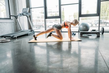 fitness mat spor salonunda aerobik egzersiz yaparak sporcumuz yan görünüm