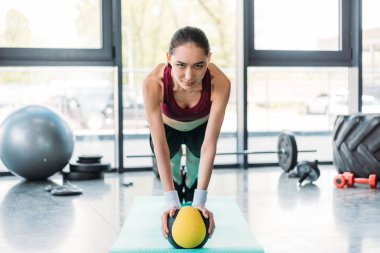 Genç Asyalı sporcumuz topa spor salonunda fitness mat Dengeleme