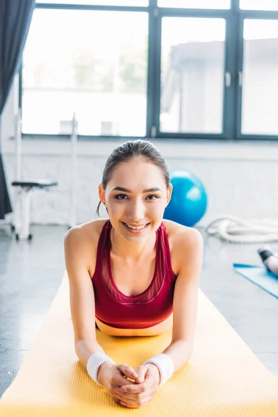 Lächelnde Asiatische Sportlerin Armbändern Auf Fitnessmatte Fitnessstudio — Stockfoto