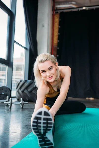 Mladá Usměvavá Sportovní Žena Táhnoucí Fitness Mat Tělocvičně — Stock fotografie