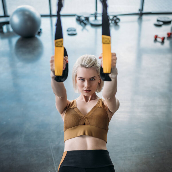 portrait of caucasian sportswoman training with resistance bands at gym