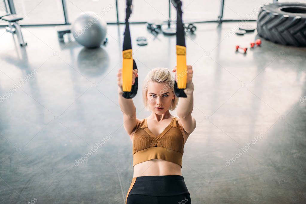 portrait of caucasian sportswoman training with resistance bands at gym