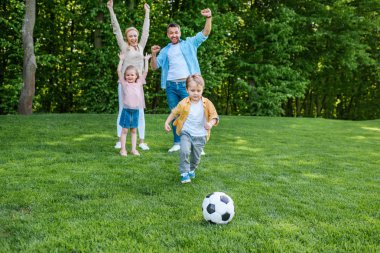 mutlu aile ile futbol topu parkta oynarken