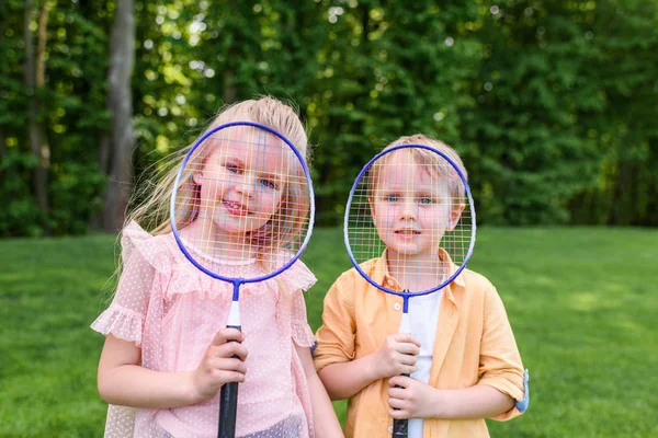 Cute Little Kids Holding Badminton Rackets Smiling Camera Park — Free Stock Photo