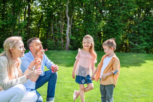 Adorabili Bambini Che Guardano Genitori Che Soffiano Bolle Sapone Nel — Foto Stock