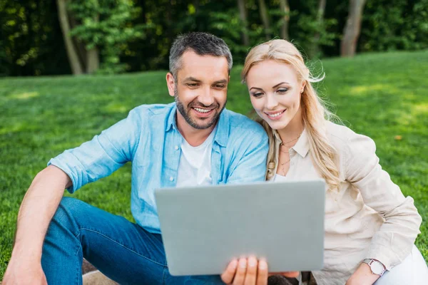 Feliz Pareja Joven Usando Ordenador Portátil Mientras Están Sentados Juntos — Foto de Stock