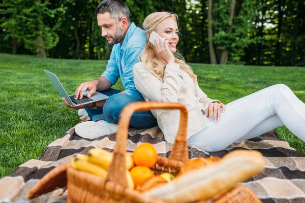 Lachende Jong Koppel Met Smartphone Laptop Picknick Het Park — Stockfoto