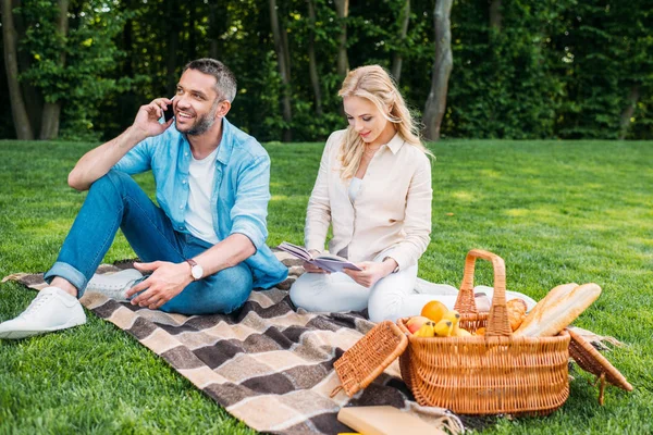 Fiatal Olvasókönyv Közben Elbeszélgettünk Kockás Piknik Parkban Smartphone Beszélő Mosolygó — Stock Fotó