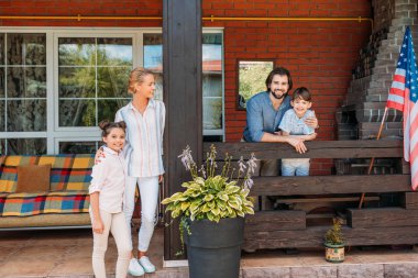 Ebeveynler ve çocuklar ülke evi verandada duran