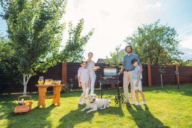 Aile ile köpek Barbekü birlikte arka bahçesinde üzerinde yaz günü partisi.