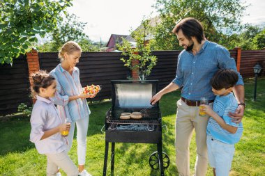 aile barbekü birlikte arka bahçesinde üzerinde yaz günü partisi.