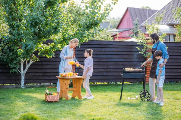 Anya Gyümölcslé Özönlenek Lánya Üveg Miközben Apa Fia Ételt Barbecue — Stock Fotó