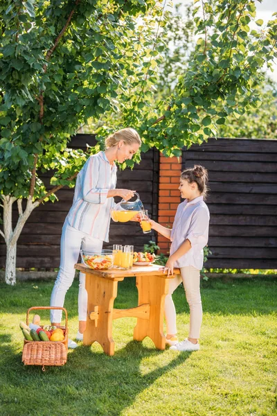 Vista Laterale Della Madre Sorridente Versando Succo Vetro Figlie Durante — Foto Stock