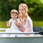 快乐的母亲与儿子一起花费时间在小船在公园