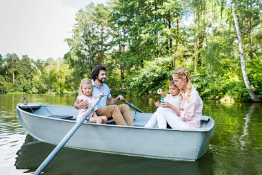 mutlu genç aile Park'ta Nehri üzerinde tekne sürme