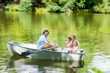 lake park, teknede genç aile binme gülümseyen