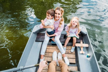 high angle view of beautiful young family riding boat on lake clipart