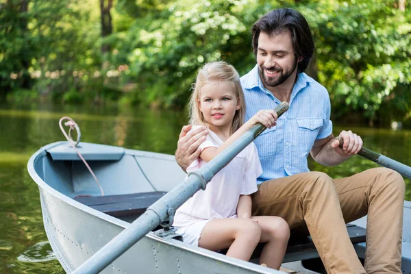 快乐的父亲和女儿乘坐小船和拥抱在湖在公园 — 免费的图库照片