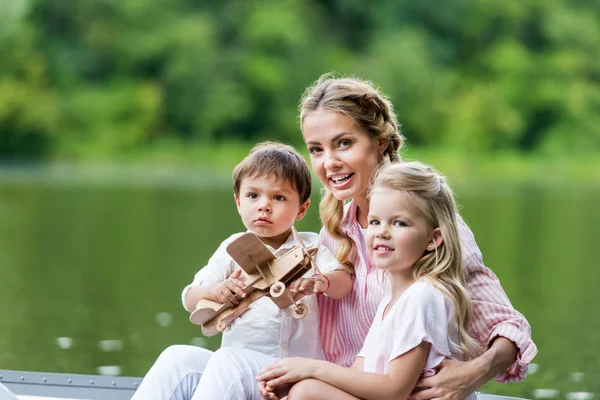年轻快乐的母亲和孩子乘坐小船在湖在公园 — 图库照片