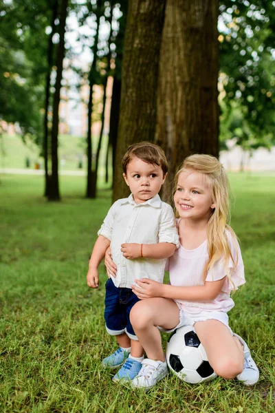 可爱的小哥哥和妹妹在公园里拥抱足球 — 图库照片