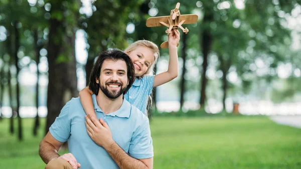 Adorable Little Daughter Embracing Happy Father Holding Toy Airplane Park — Stock Photo, Image