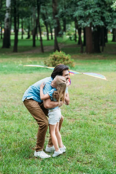 Hermoso Padre Feliz Con Cometa Abrazando Pequeña Hija Parque — Foto de stock gratis