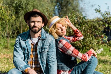 Açık havada çimenlerin üzerinde oturan çiftçi çiftin seçici odak 