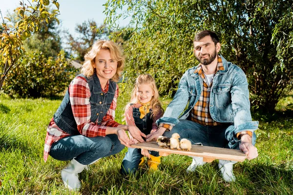 Famiglia Contadina Con Figlia Che Tiene Bordo Legno Con Adorabili Fotografia Stock